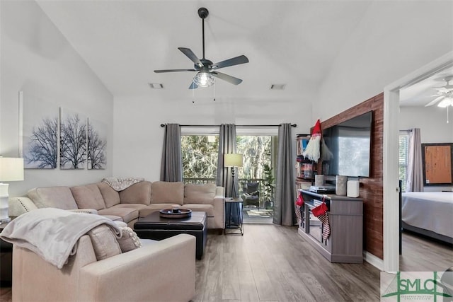 living room featuring high vaulted ceiling and light hardwood / wood-style floors