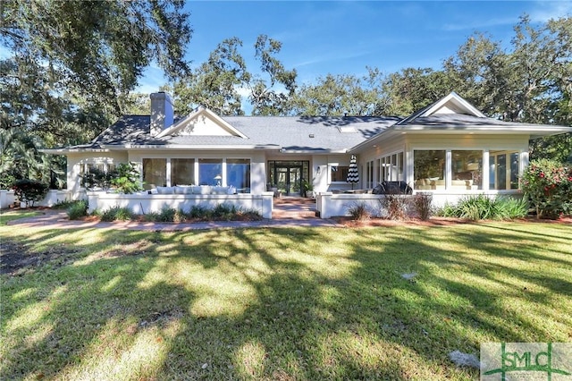 rear view of house featuring a lawn and french doors