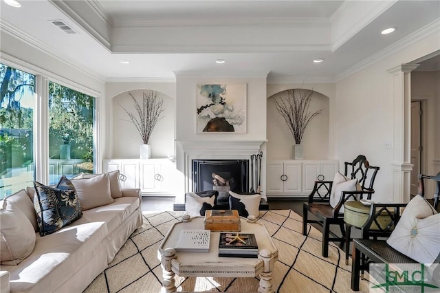 living room with light wood-type flooring, ornate columns, and crown molding