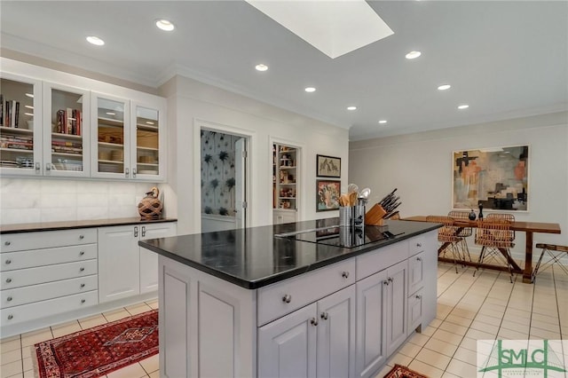 kitchen with decorative backsplash, black electric cooktop, white cabinetry, and crown molding