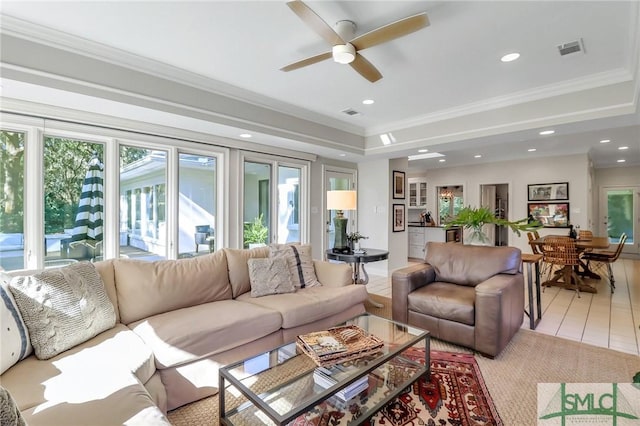 tiled living room with ceiling fan and ornamental molding