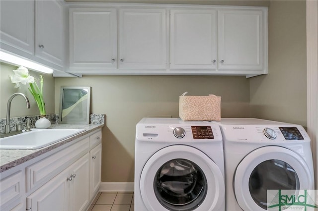 laundry area with washer and clothes dryer, sink, light tile patterned flooring, and cabinets