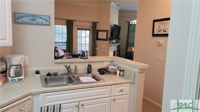 kitchen featuring white cabinets, dishwasher, crown molding, and sink