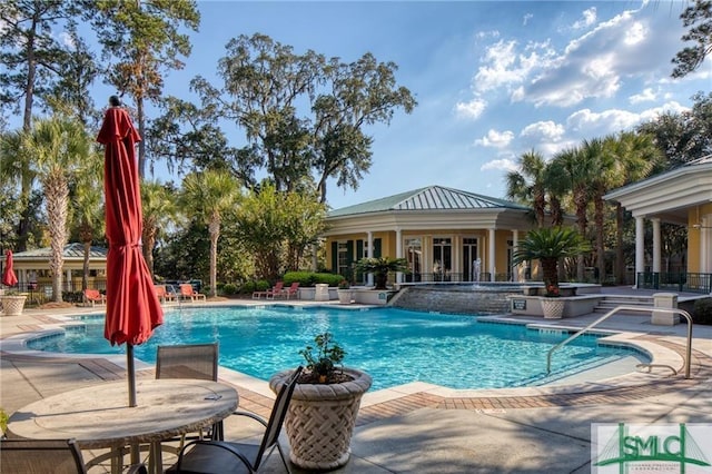 view of swimming pool featuring pool water feature and a patio area