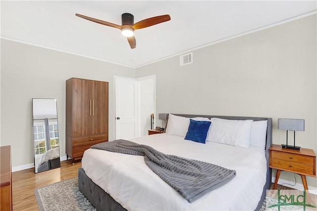 bedroom with ceiling fan, crown molding, and light wood-type flooring