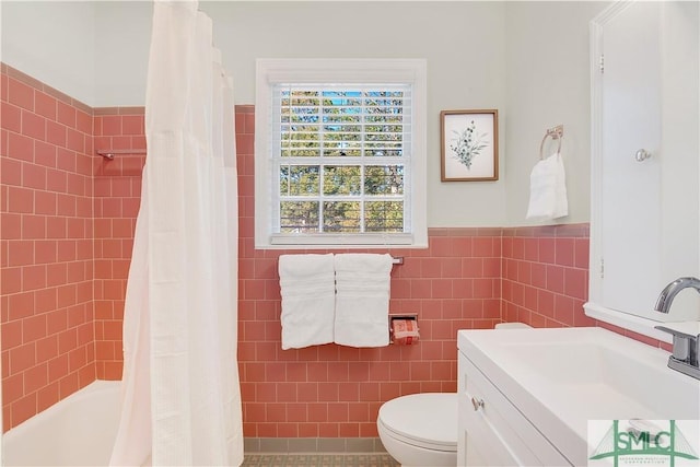 bathroom with tile patterned floors, vanity, tile walls, and toilet