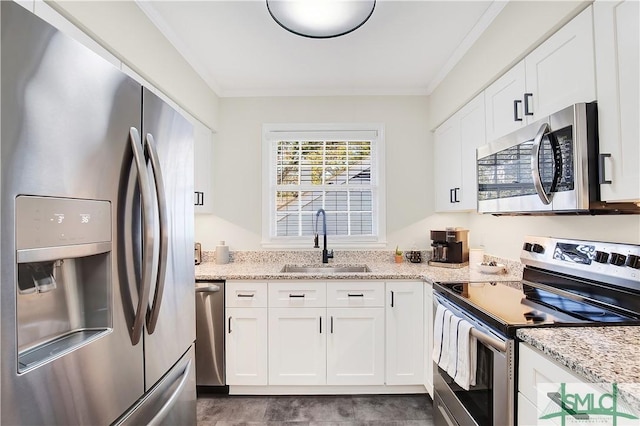 kitchen with light stone countertops, appliances with stainless steel finishes, crown molding, sink, and white cabinetry