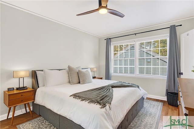 bedroom featuring ceiling fan, hardwood / wood-style floors, and crown molding