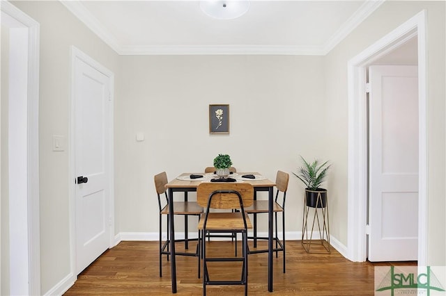 dining space featuring hardwood / wood-style floors and crown molding