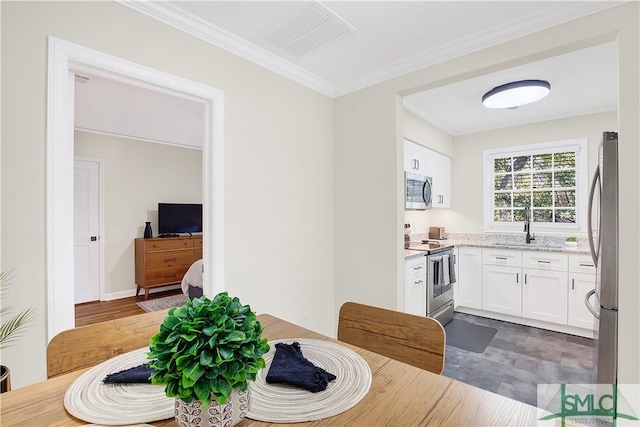 dining room with crown molding, sink, and wood-type flooring