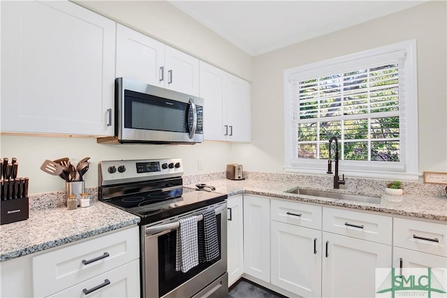 kitchen with white cabinets, light stone countertops, sink, and appliances with stainless steel finishes