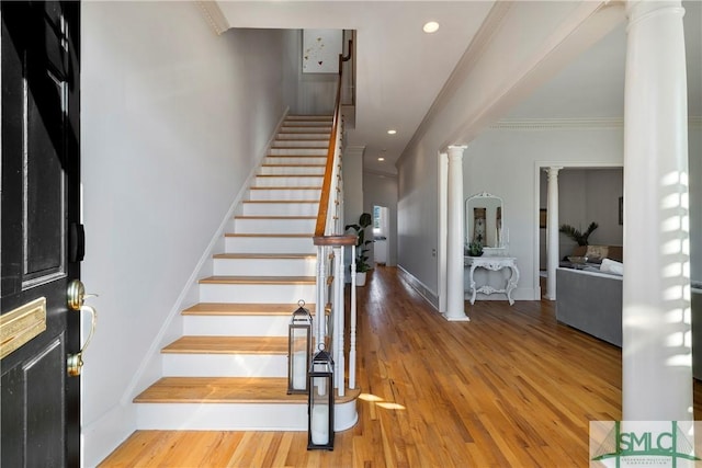 staircase with crown molding and wood-type flooring