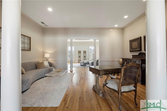 living room with ornamental molding, decorative columns, and light hardwood / wood-style floors