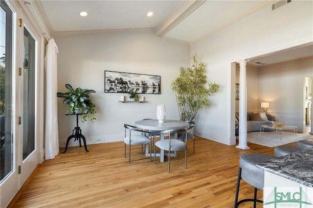 dining space with ornate columns, crown molding, vaulted ceiling, and light wood-type flooring