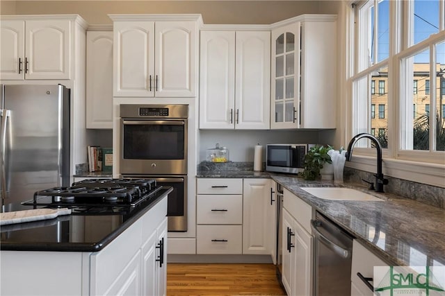 kitchen featuring white cabinets, stainless steel appliances, and sink