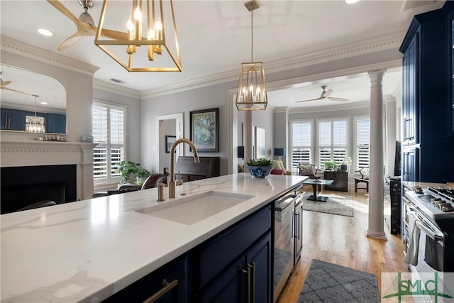 kitchen featuring a healthy amount of sunlight, light wood-type flooring, sink, and ornamental molding