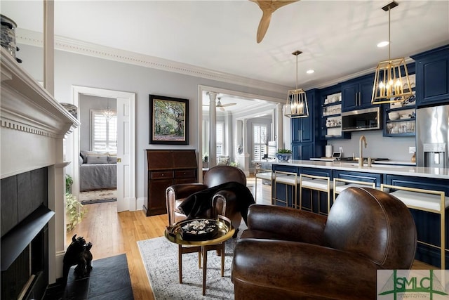 kitchen featuring light hardwood / wood-style floors, blue cabinets, a healthy amount of sunlight, and sink