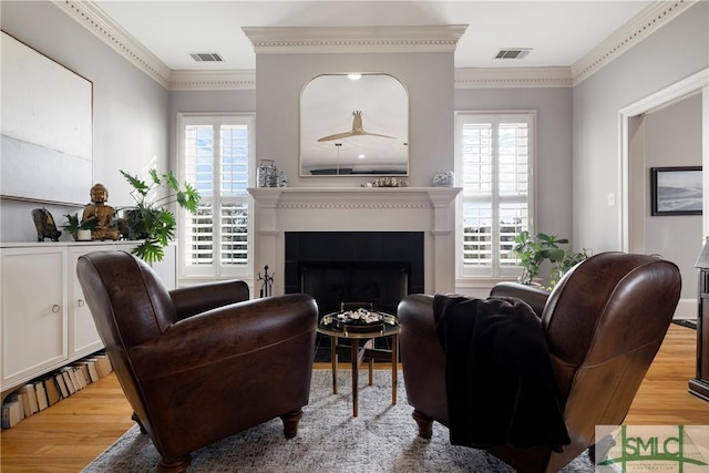 living room with light wood-type flooring and ornamental molding