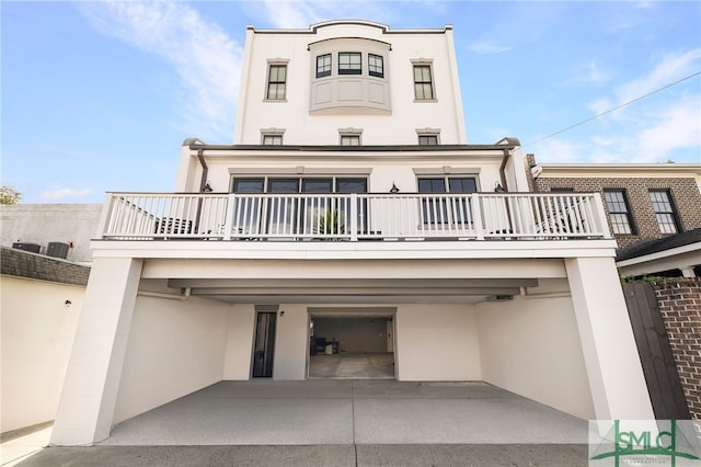 back of property featuring a garage and a balcony