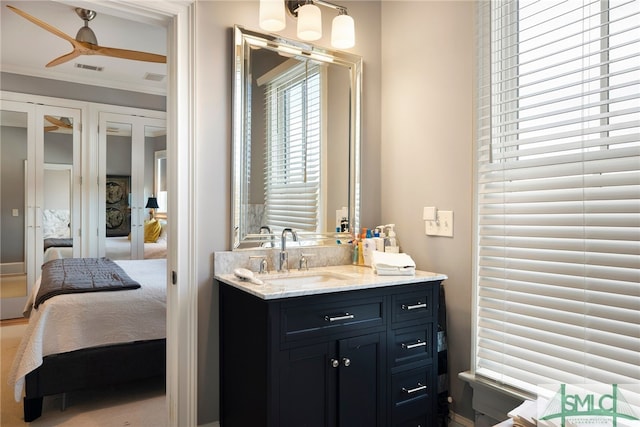 bathroom featuring vanity, ceiling fan, and crown molding