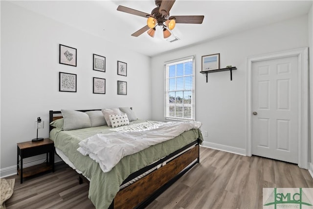 bedroom with hardwood / wood-style floors and ceiling fan