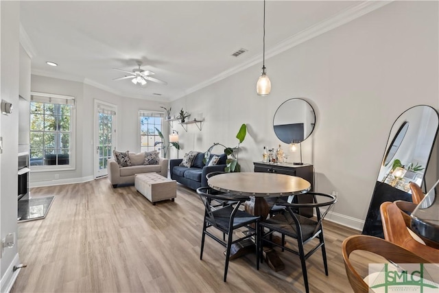 dining space featuring light wood-type flooring, ceiling fan, and ornamental molding