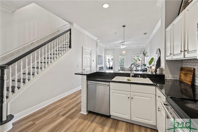 kitchen with kitchen peninsula, white cabinetry, stainless steel dishwasher, and sink