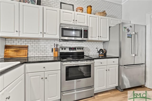 kitchen with backsplash, stainless steel appliances, and white cabinetry