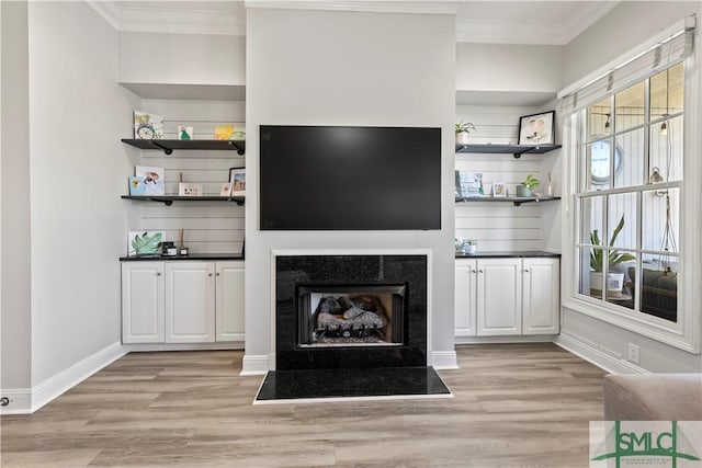 unfurnished living room with light hardwood / wood-style flooring and crown molding