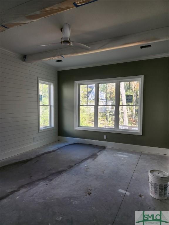 empty room with a wealth of natural light, ornamental molding, and ceiling fan