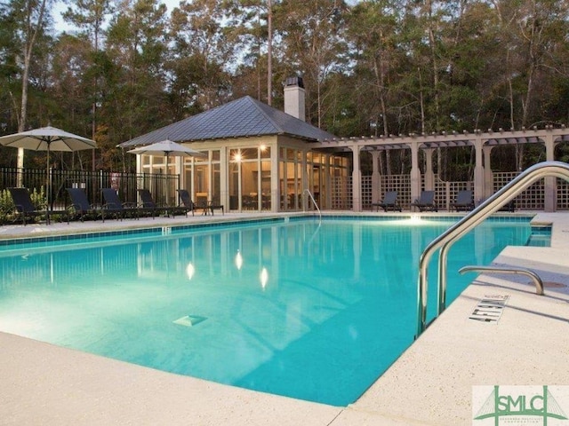 community pool with a patio area, fence, and a pergola