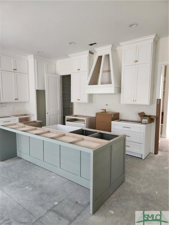 kitchen featuring a center island, premium range hood, and white cabinetry