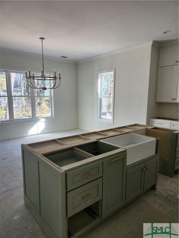 kitchen featuring ornamental molding, sink, green cabinetry, a chandelier, and hanging light fixtures