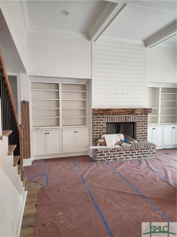 unfurnished living room with ornamental molding, a brick fireplace, and built in features