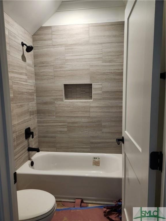 bathroom with bathtub / shower combination, vaulted ceiling, and toilet