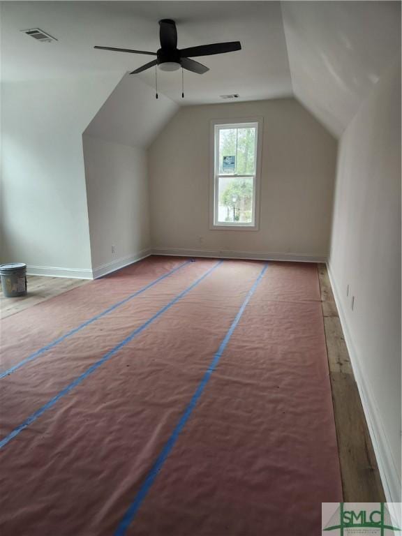 additional living space featuring a ceiling fan, visible vents, vaulted ceiling, and baseboards