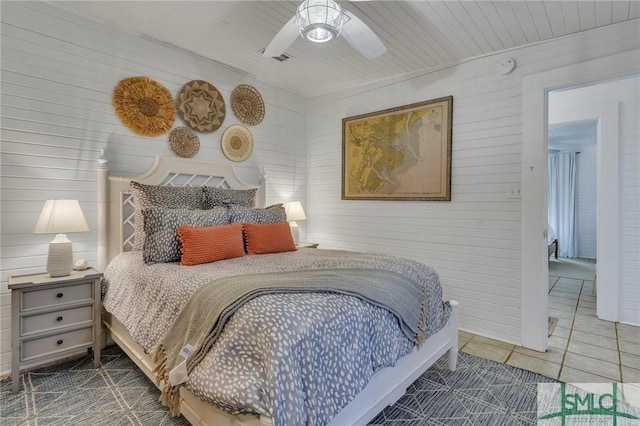 tiled bedroom with ceiling fan, wood walls, and wooden ceiling