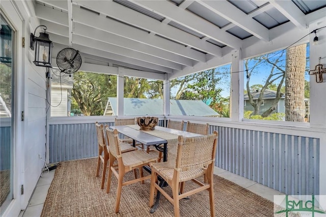 sunroom / solarium featuring vaulted ceiling with beams