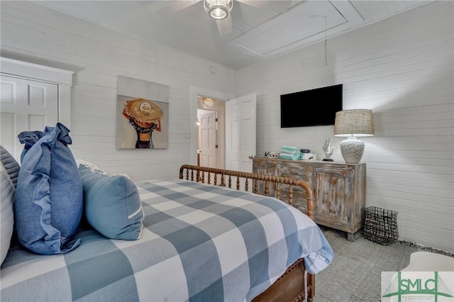 bedroom with ceiling fan and wood walls