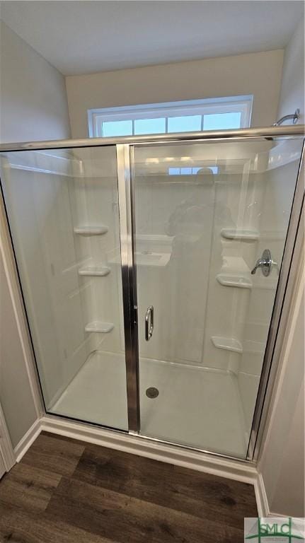 bathroom featuring hardwood / wood-style floors and a shower with shower door