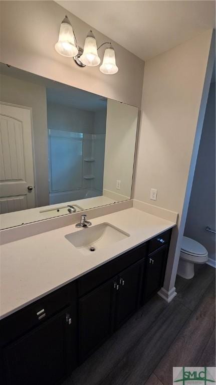 bathroom featuring walk in shower, vanity, wood-type flooring, and toilet