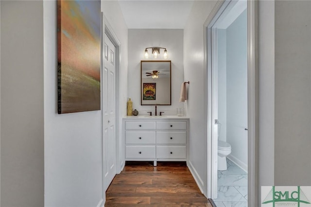 hall featuring baseboards, marble finish floor, and a sink