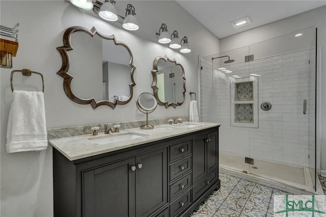 bathroom featuring double vanity, a stall shower, and a sink