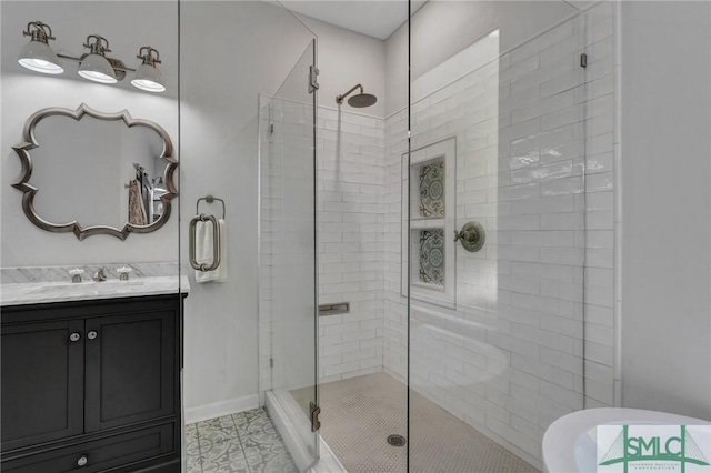 bathroom featuring baseboards, a stall shower, and vanity