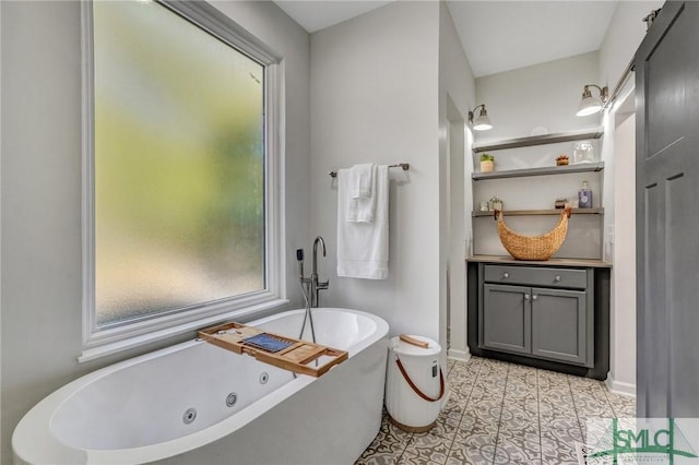 bathroom with vanity, a soaking tub, baseboards, and tile patterned flooring