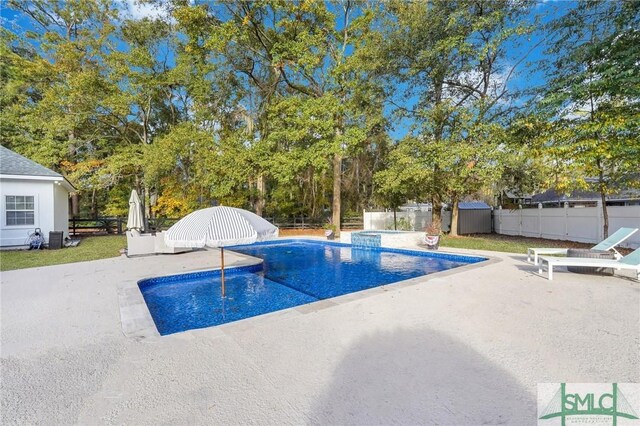 view of pool with a patio, a fenced backyard, and a pool with connected hot tub