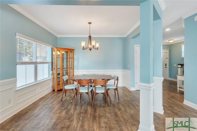 dining space featuring a chandelier, dark hardwood / wood-style floors, decorative columns, and ornamental molding