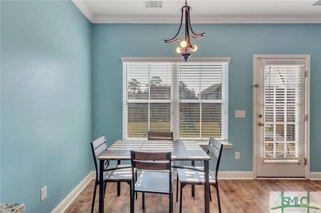 dining space with hardwood / wood-style flooring and ornamental molding