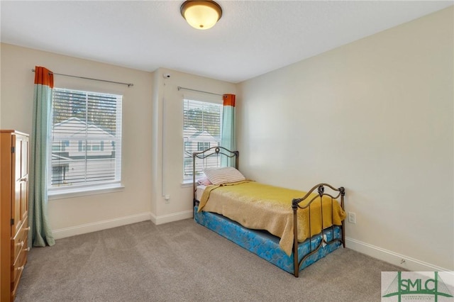 bedroom with light colored carpet and multiple windows