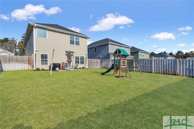 back of house with a yard and a playground